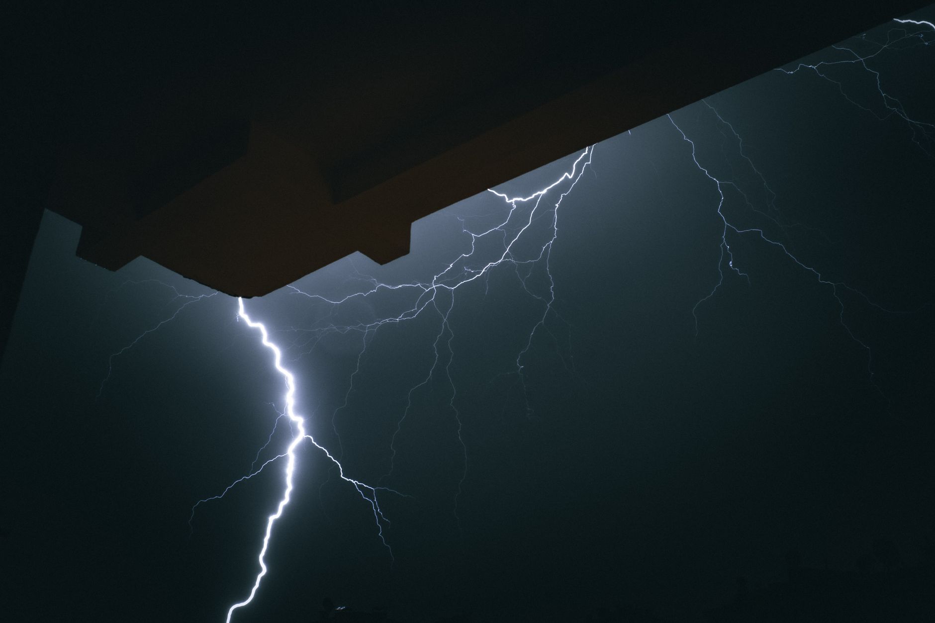 A striking lightning bolt illuminates the night sky in Türkiye, captured outdoors.