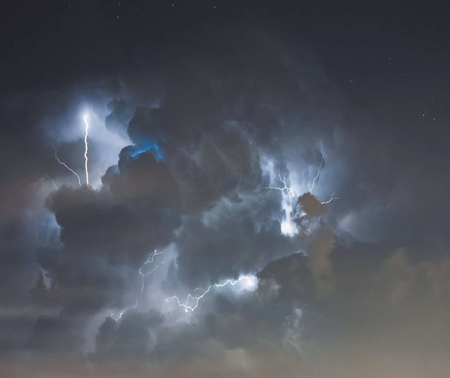 Electrifying lightning bolts illuminate the stormy night sky, creating a dramatic and intense atmosphere.