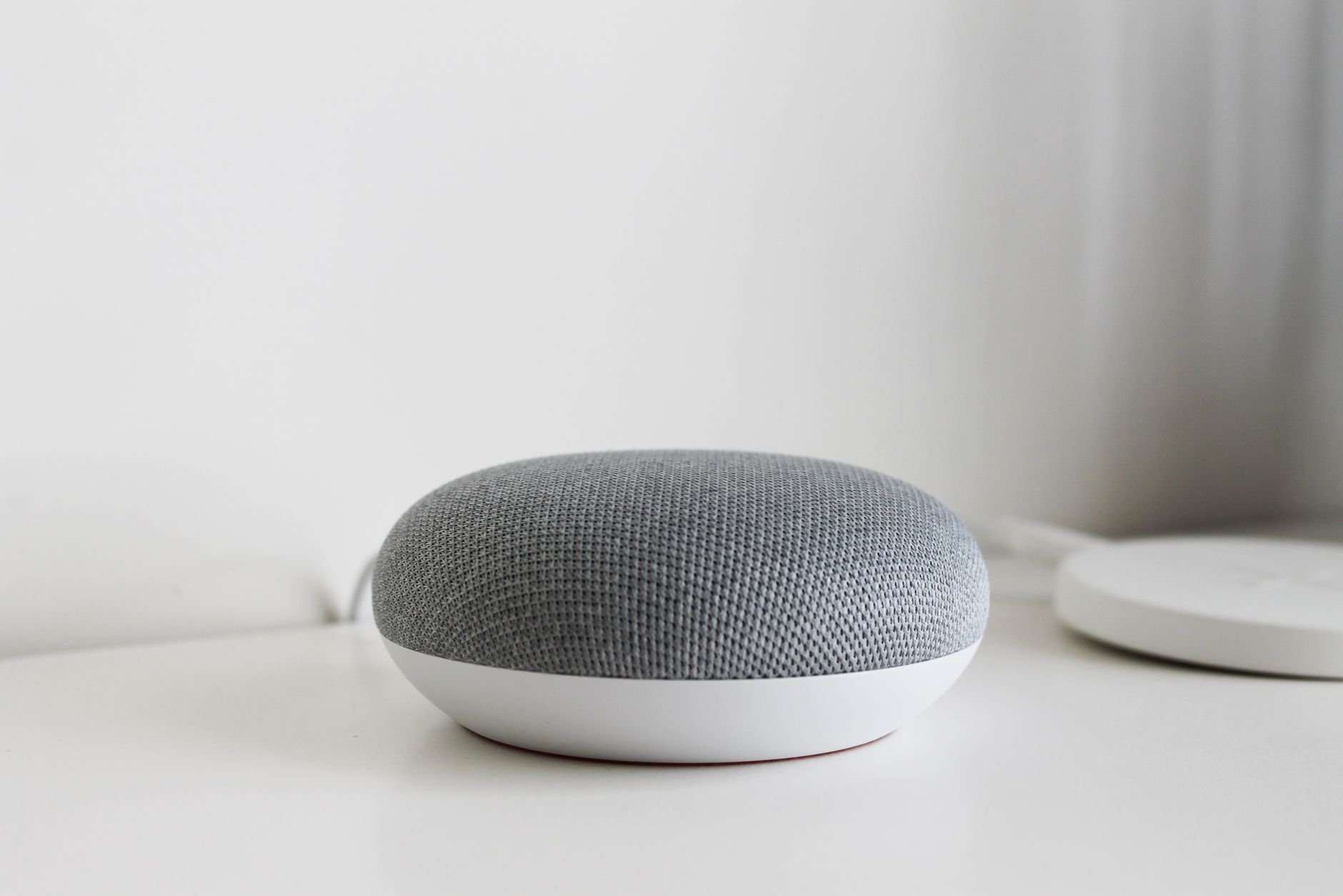 A sleek and modern smart speaker on a clean white surface, perfect for tech-inspired decor.