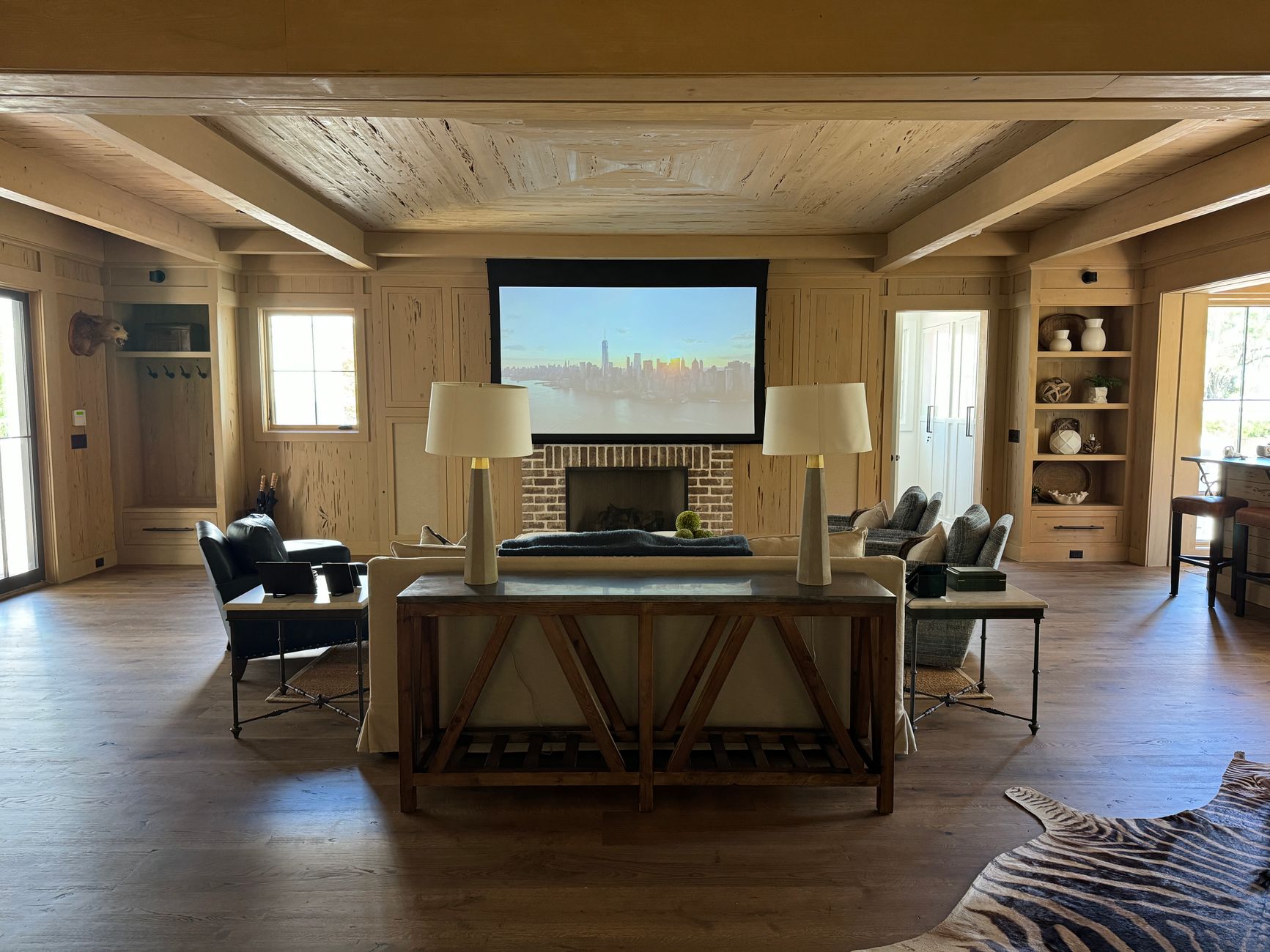 Stylish living room with projector screen, cozy seating, and wooden décor.