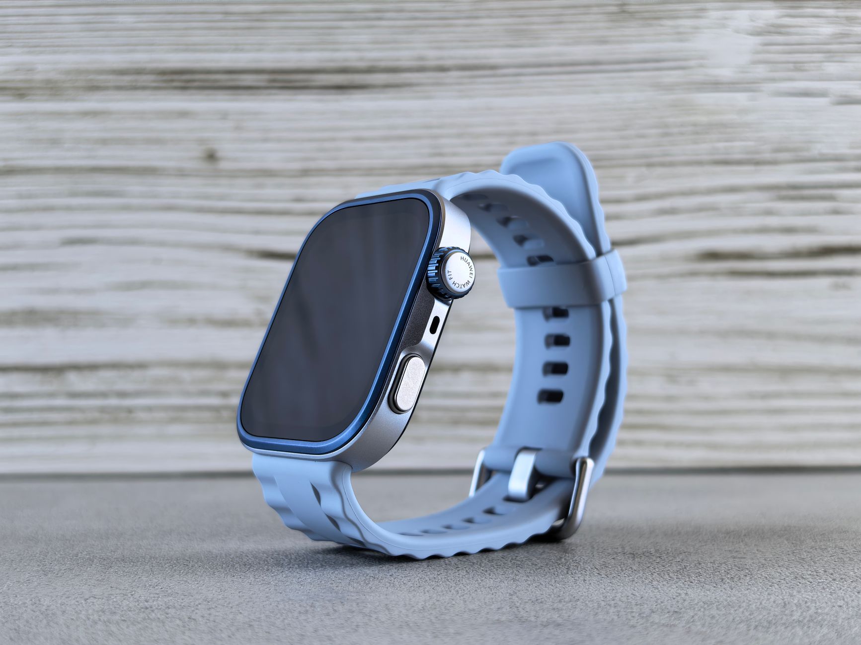 Stylish modern smartwatch with a blue strap displayed on a wooden surface, perfect for everyday wear.