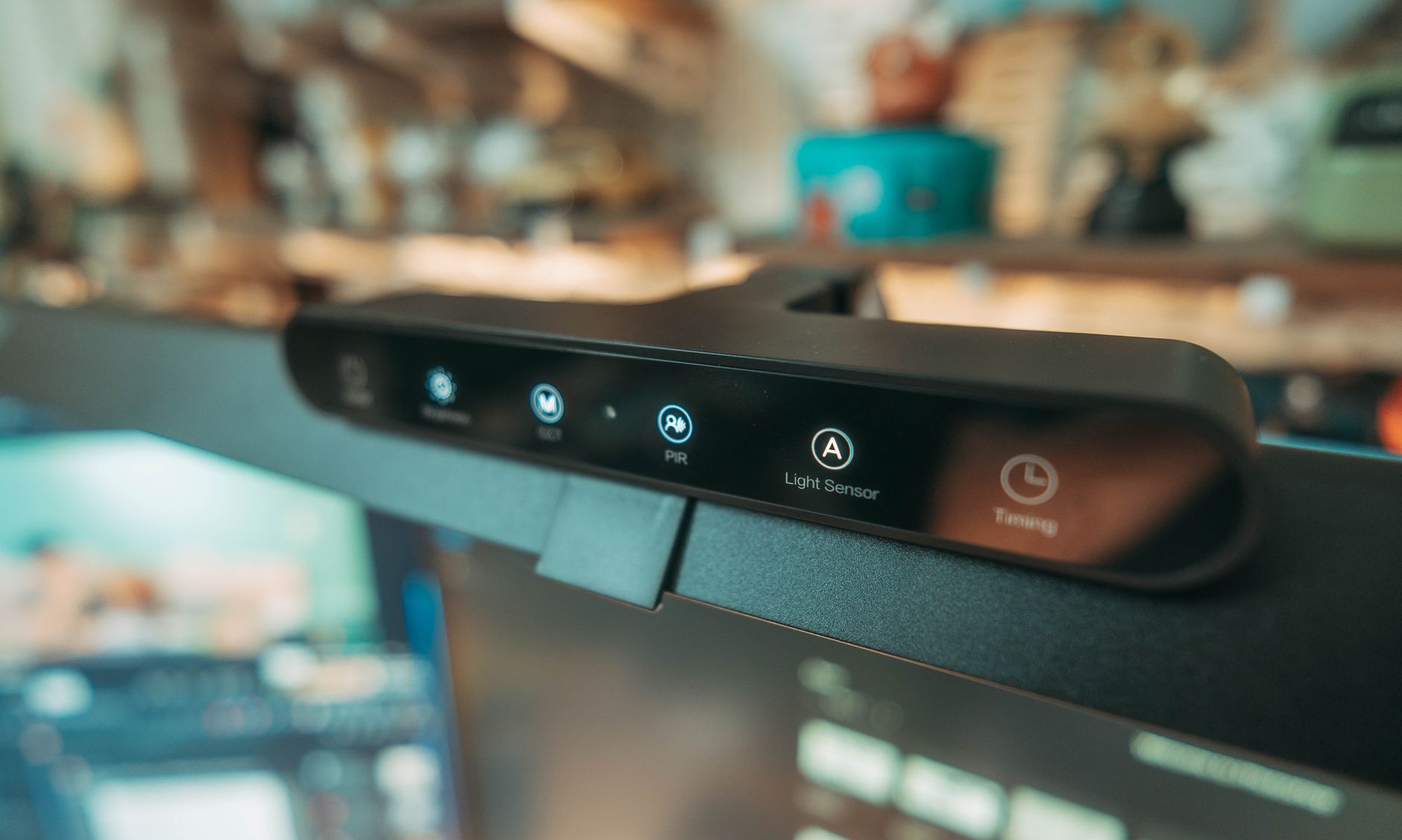 Close-up of a modern desk lamp featuring a LED display with a light sensor for smart home setups.