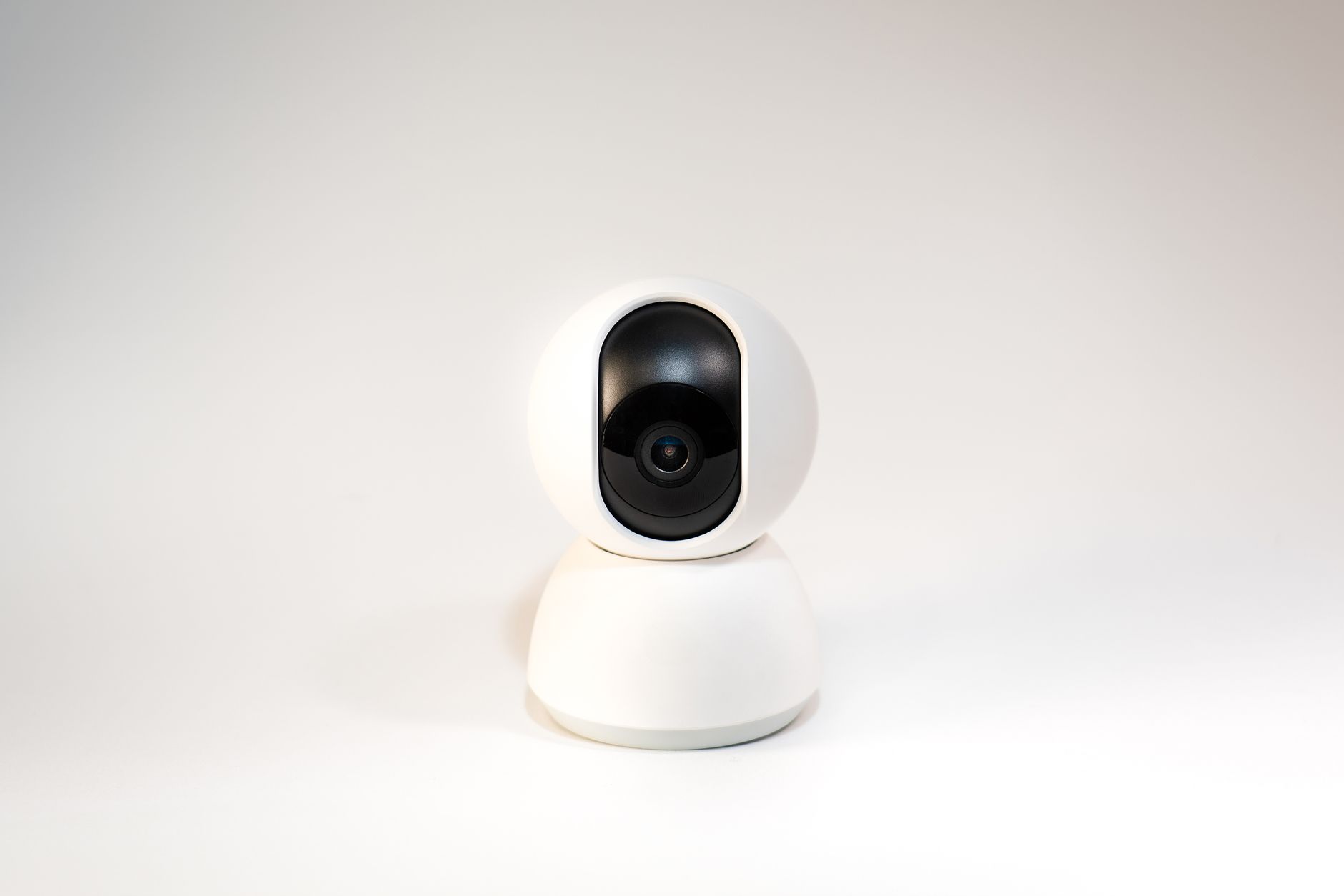 A sleek, white minimalistic smart home security camera on a white background.