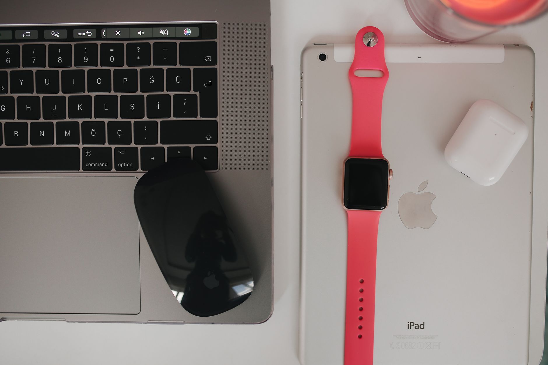 Overhead view of wireless technology gadgets including a laptop, tablet, smartwatch, and earphones.