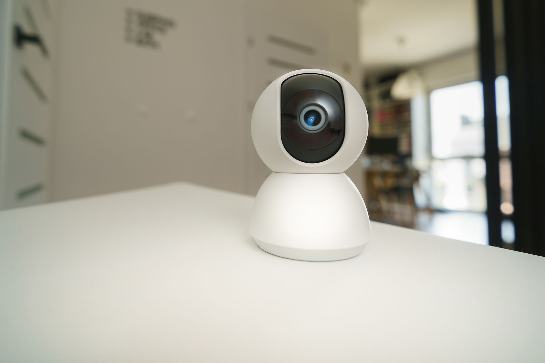 Close-up of a smart home surveillance camera on a table in an interior setting