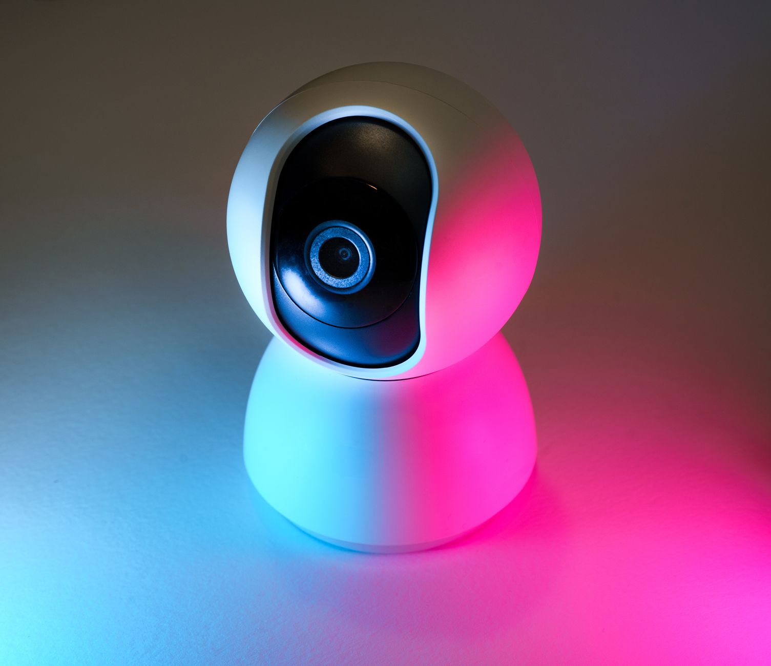 Stylish smart camera in vibrant blue and pink neon lighting, ideal for tech themes.